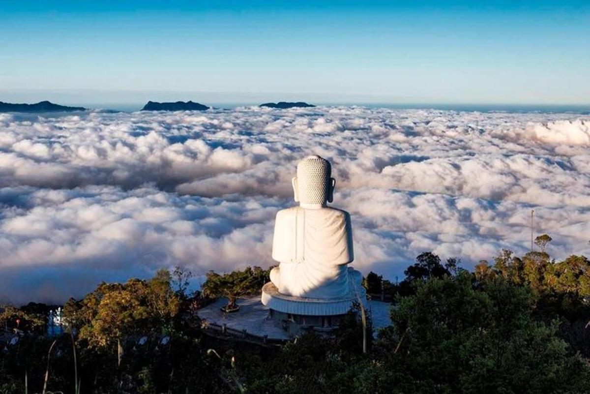 um buda sentado no topo de um campo de nuvens
