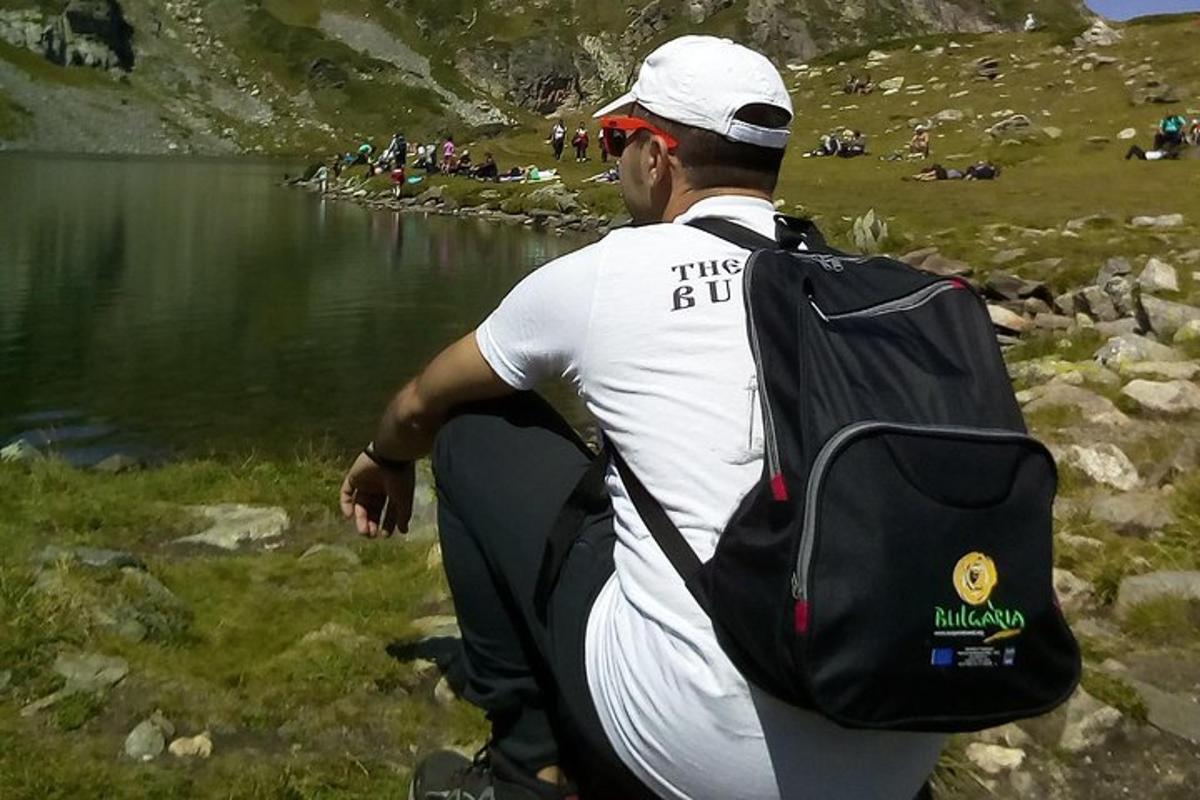 un uomo con uno zaino che cammina accanto a un lago