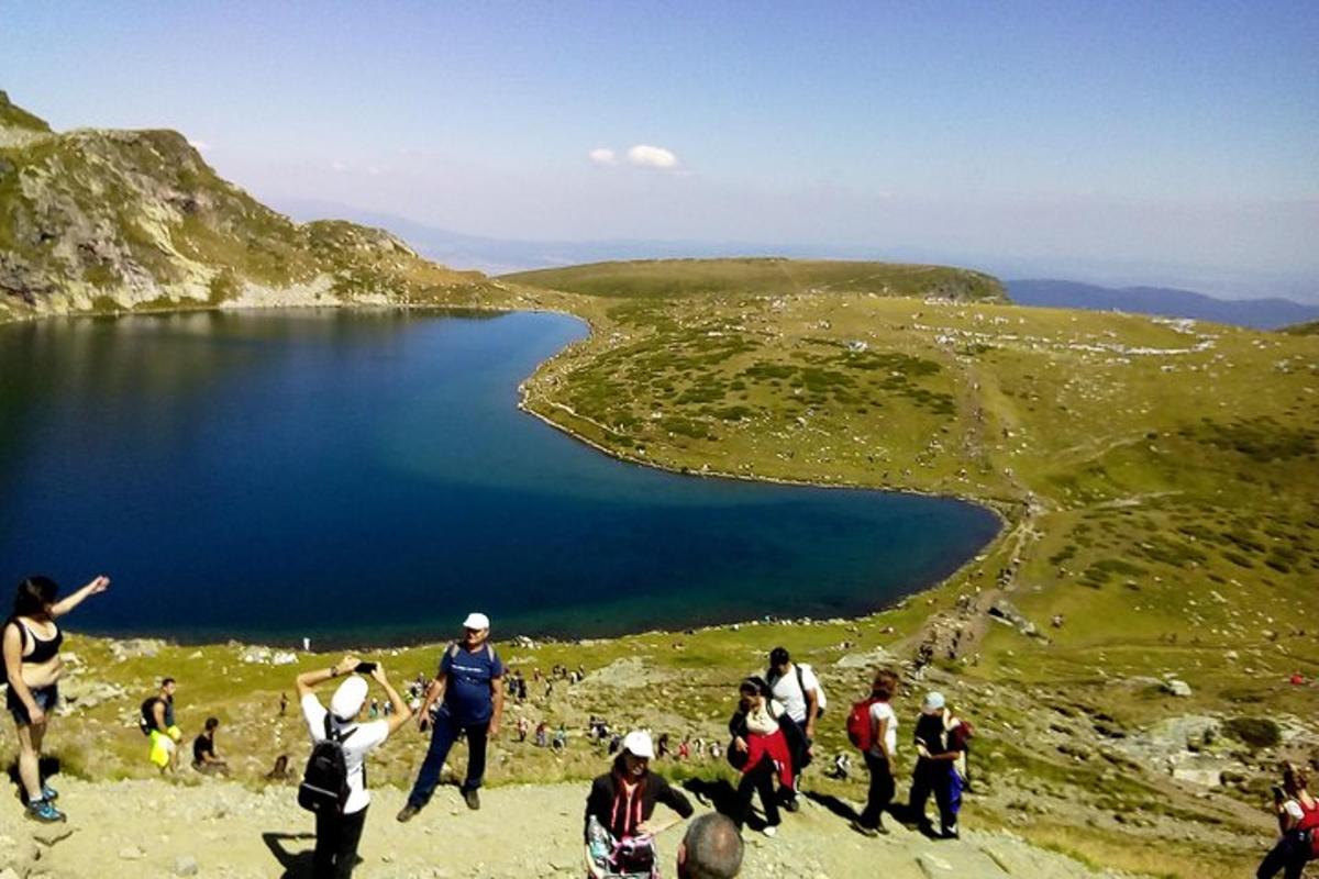 un gruppo di persone in piedi su una collina vicino a un lago
