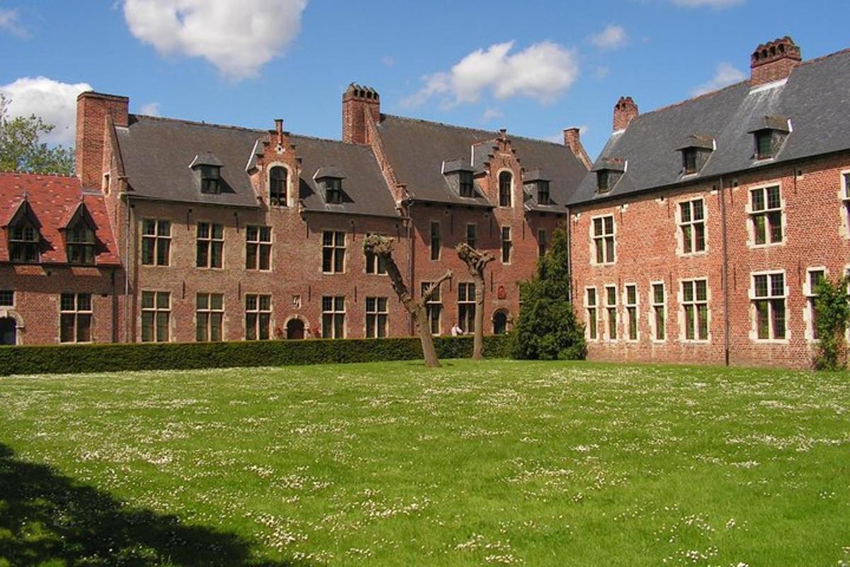 um grande edifício de tijolos com um grande campo de grama na frente