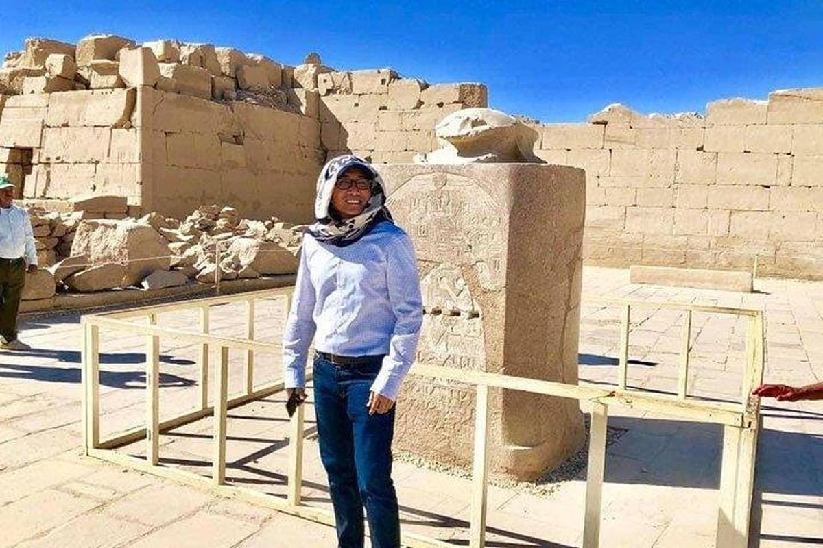una donna è in piedi davanti a una statua