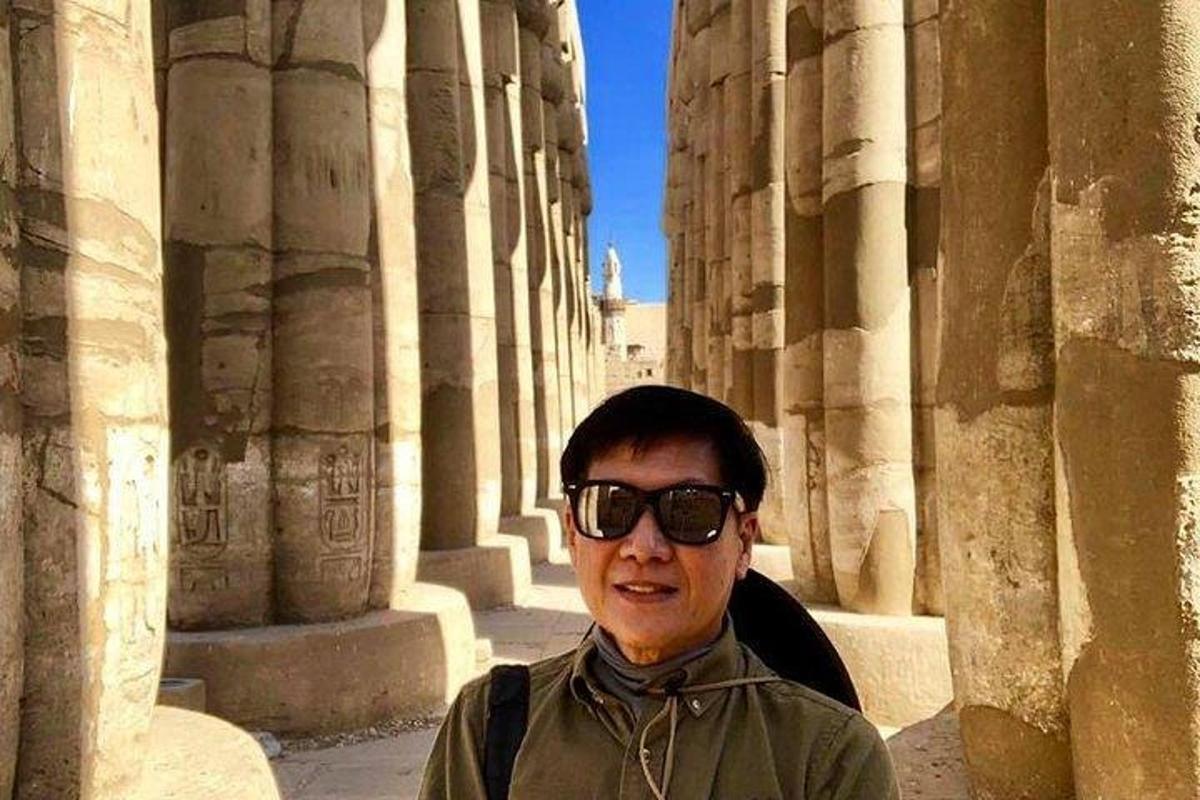 un uomo in piedi davanti a un edificio con colonne