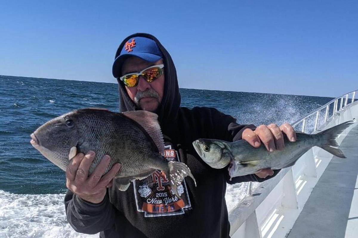 a man holding two fish in his hands on a boat