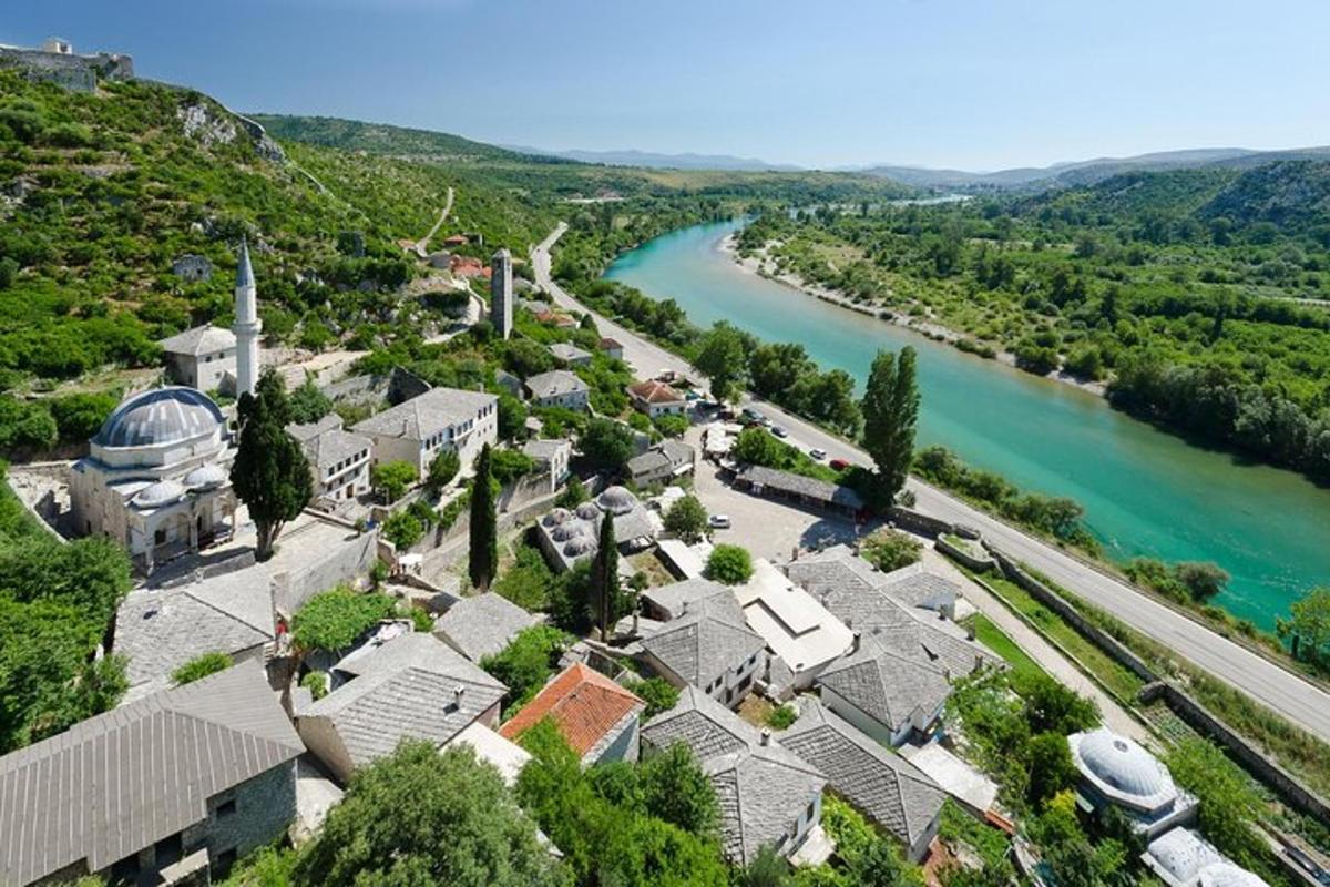 an aerial view of a village next to a river