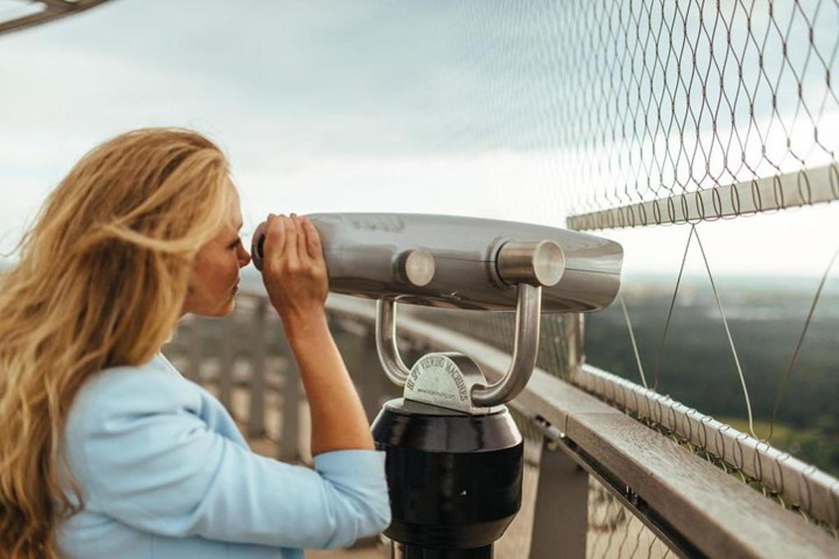 a woman is looking through a telescope on a bridge