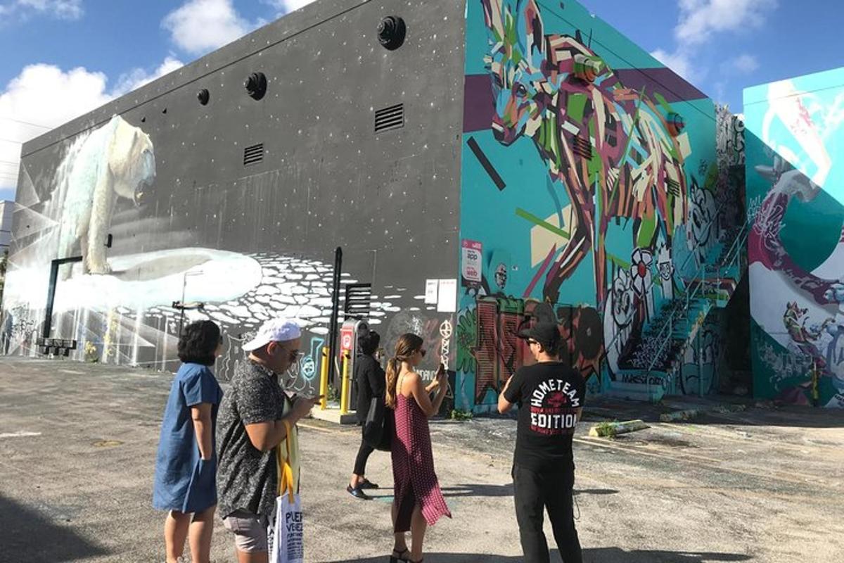 un grup de persones dempeus davant d'un edifici amb un mural