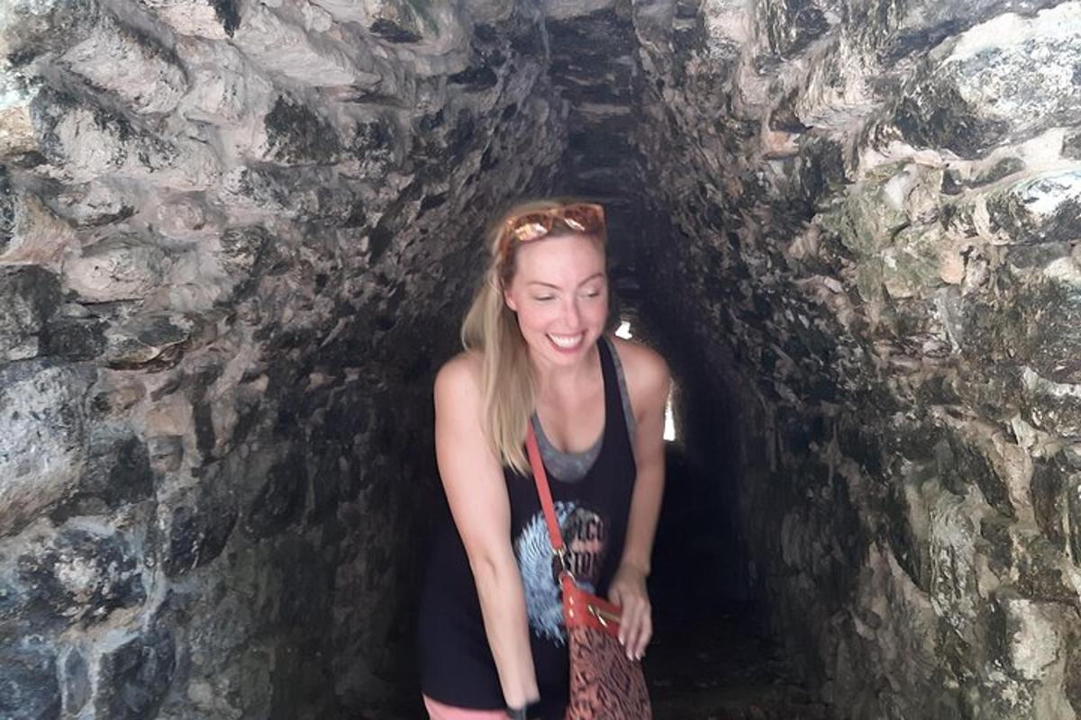 a woman standing in a tunnel in a cave