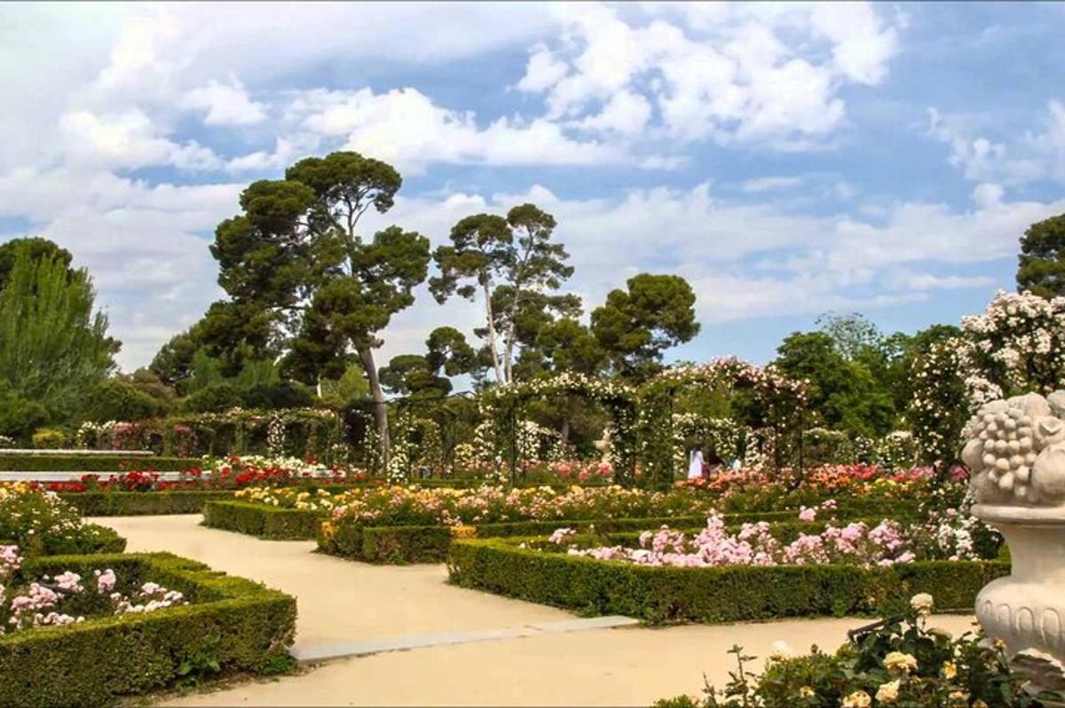 a garden with flowers and a statue in the middle
