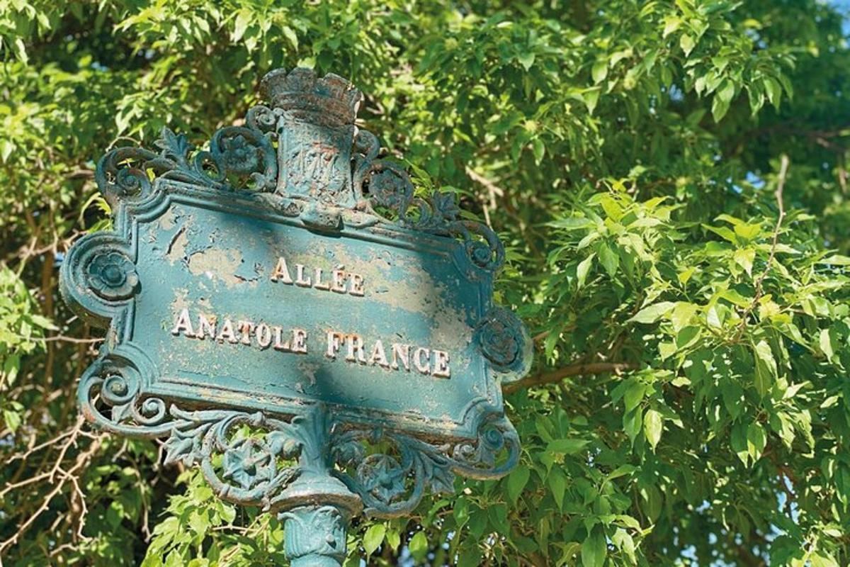 un cartello su un palo davanti a un albero