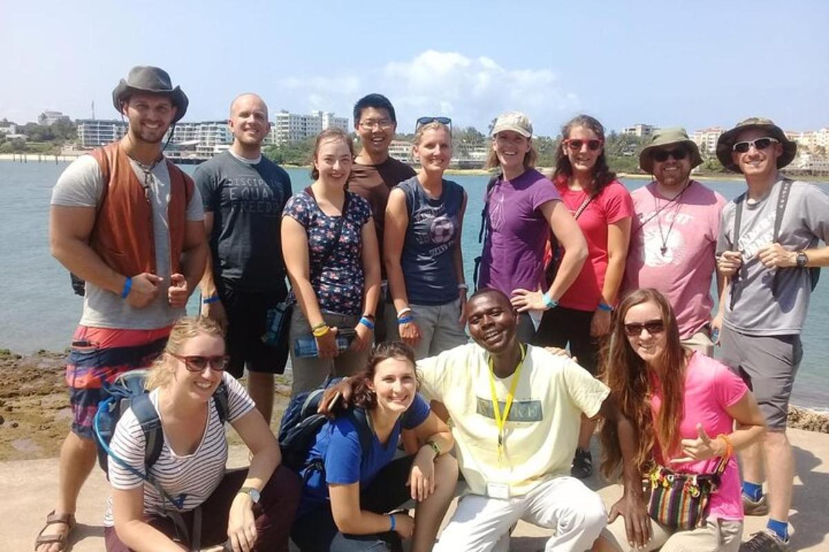 a group of people posing for a picture on the beach