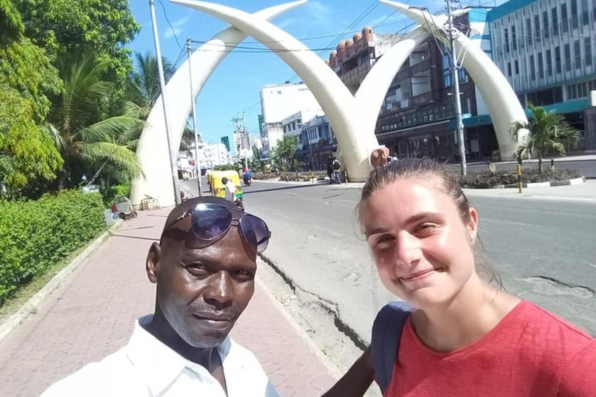 a woman standing next to a statue of a man