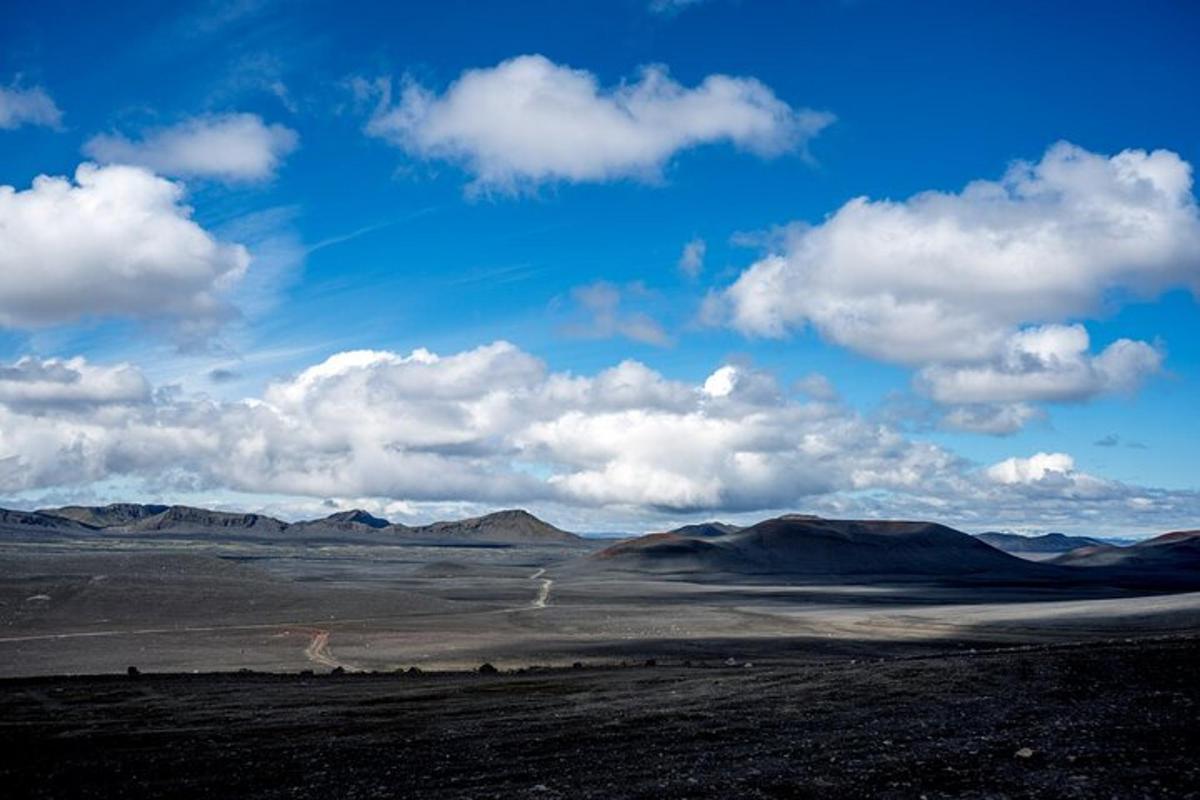 una vista di un deserto con montagne e cielo nuvoloso