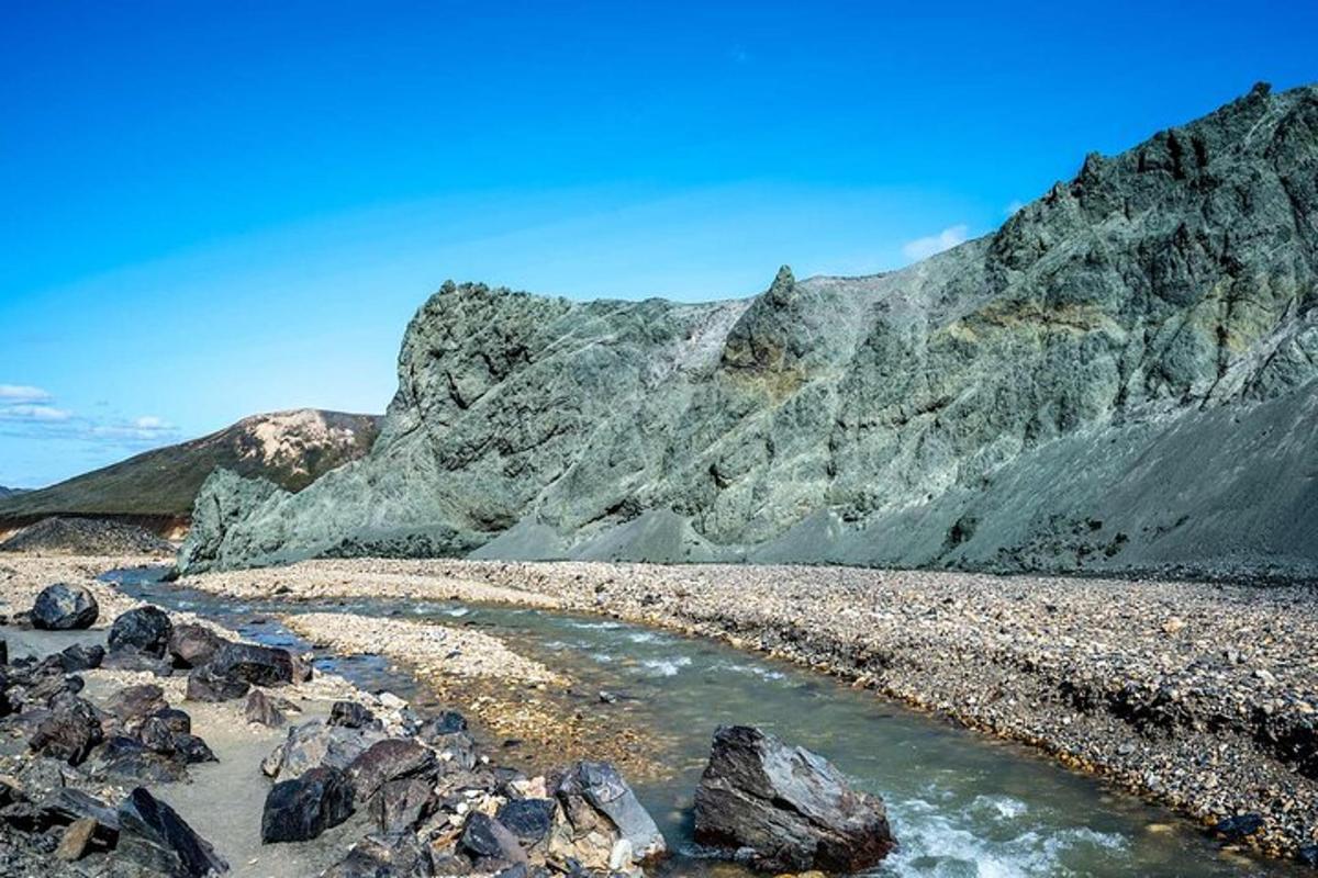 una spiaggia rocciosa con una montagna sullo sfondo