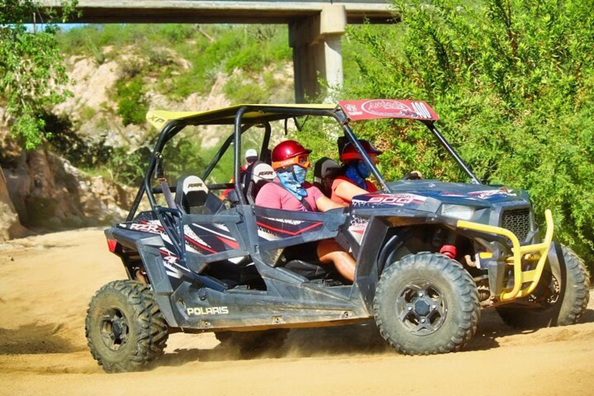 a group of people riding in a atv on a dirt road