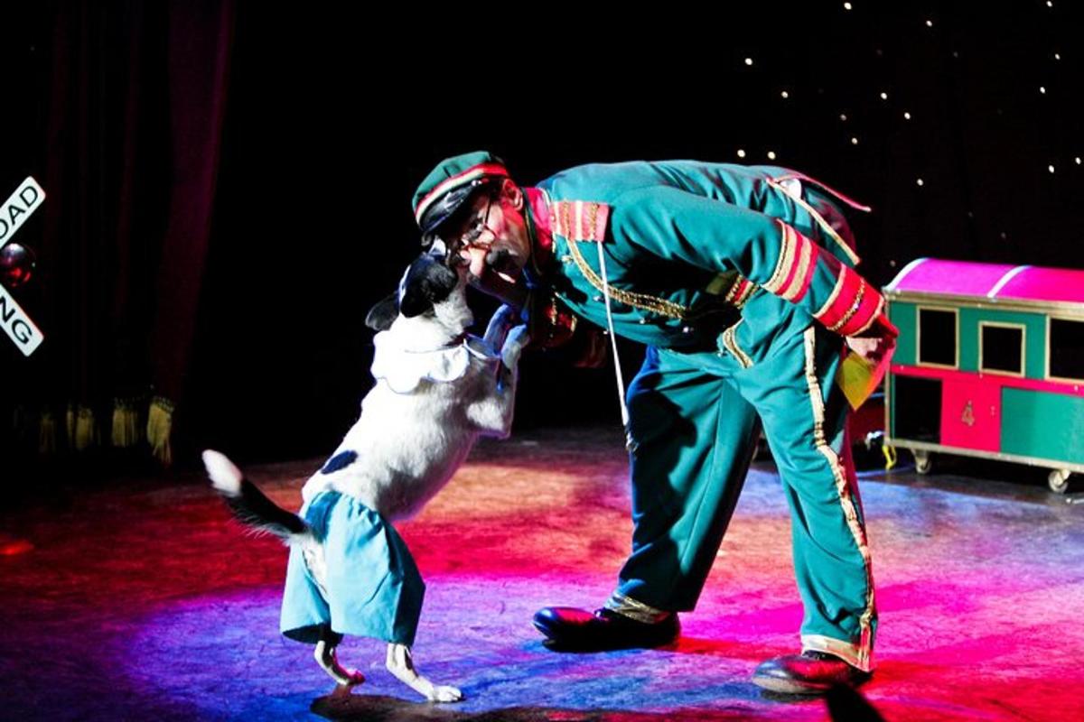 a man standing next to a dog on a stage