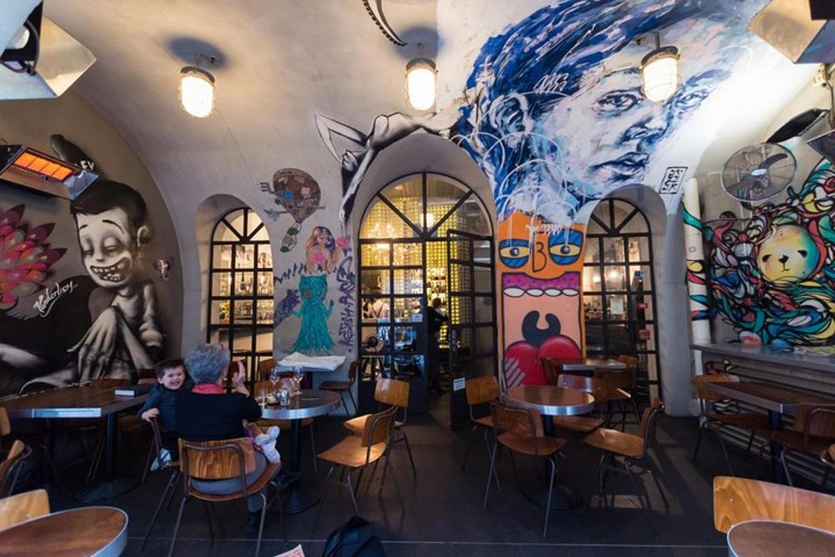 un ristorante con un murale sul muro e persone sedute ai tavoli