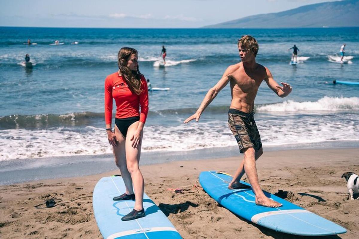 duas pessoas em pé em pranchas de surfe na praia