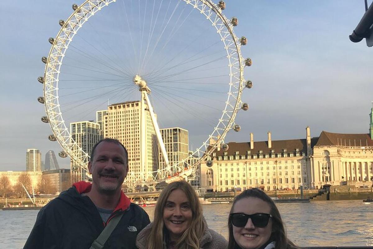 three people standing in front of a ferris wheel