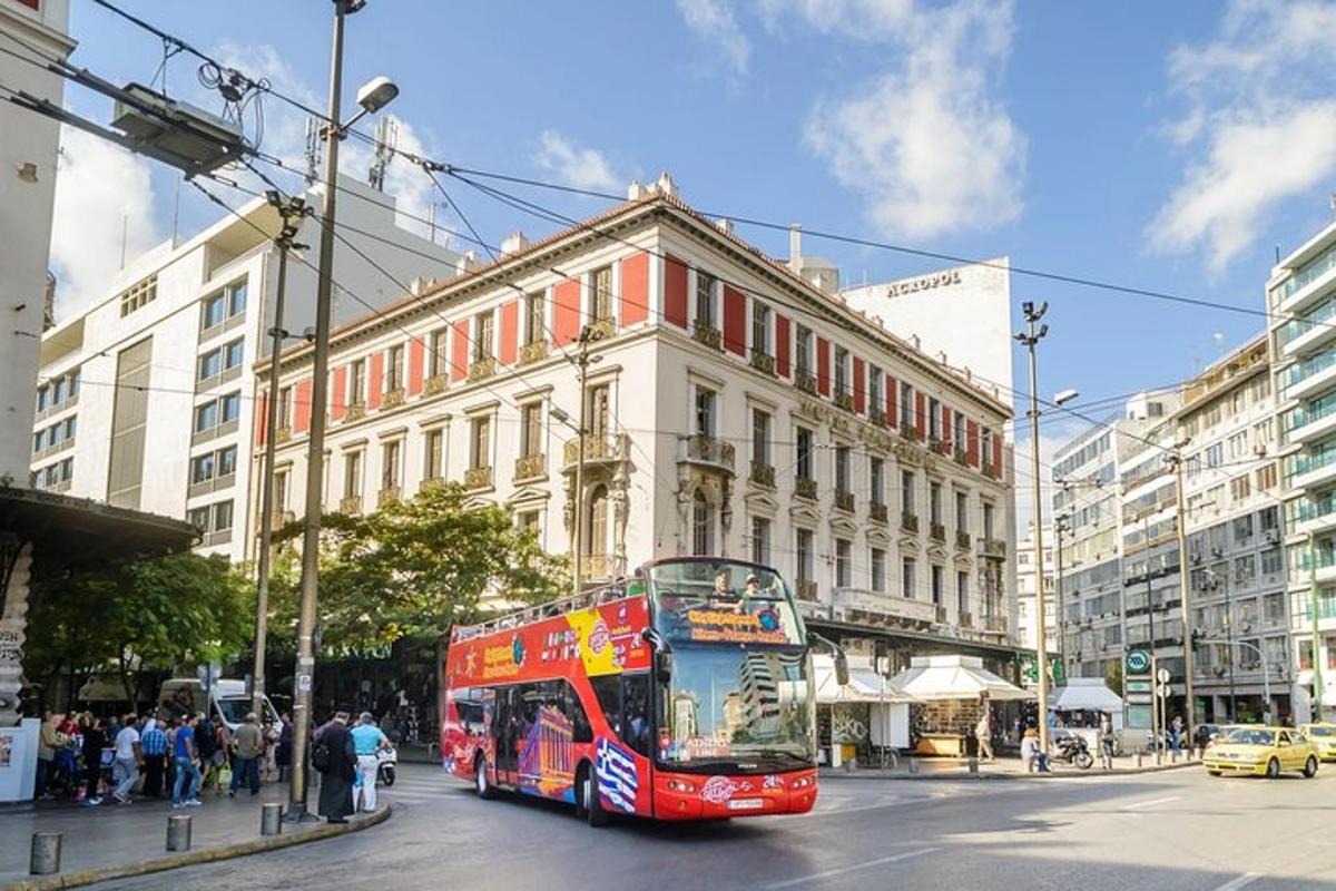 a red double decker bus driving down a city street