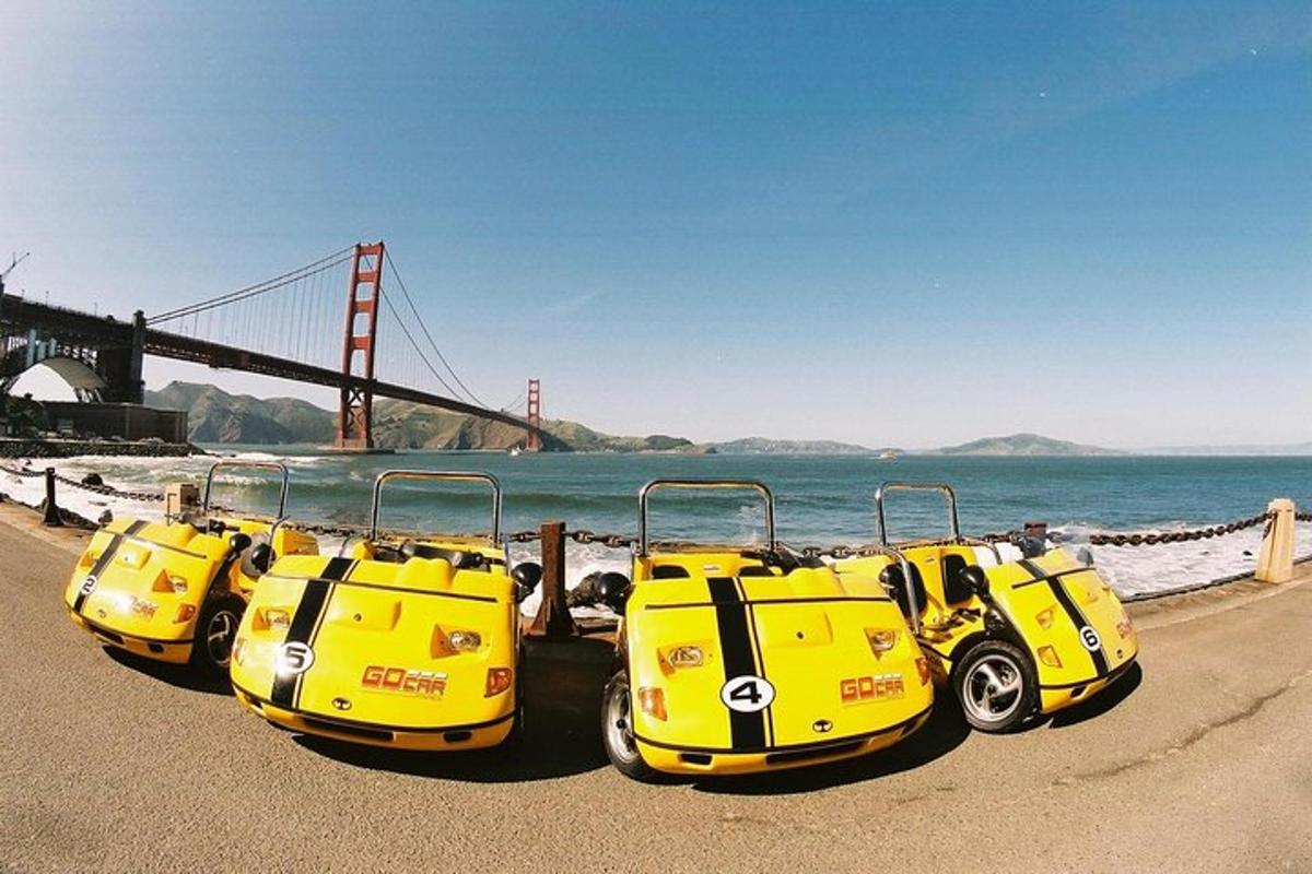 a group of yellow cars parked in front of a bridge