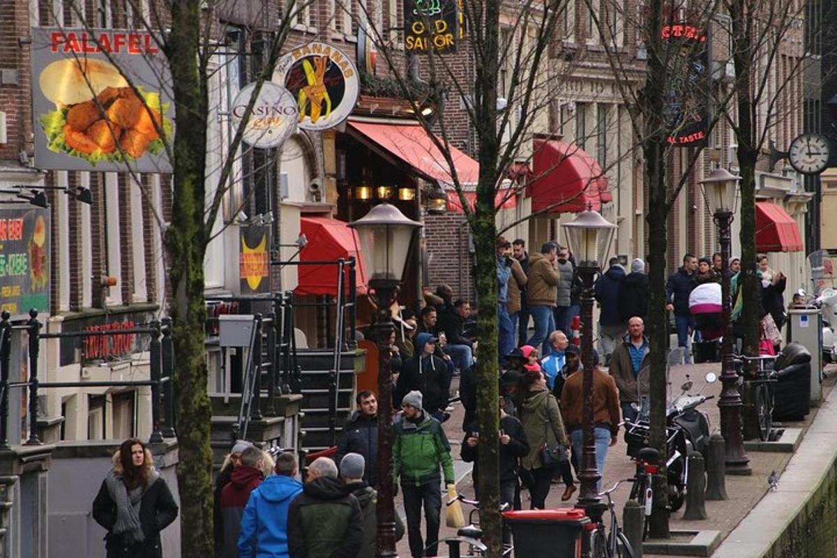 uma multidão de pessoas caminhando por uma rua da cidade