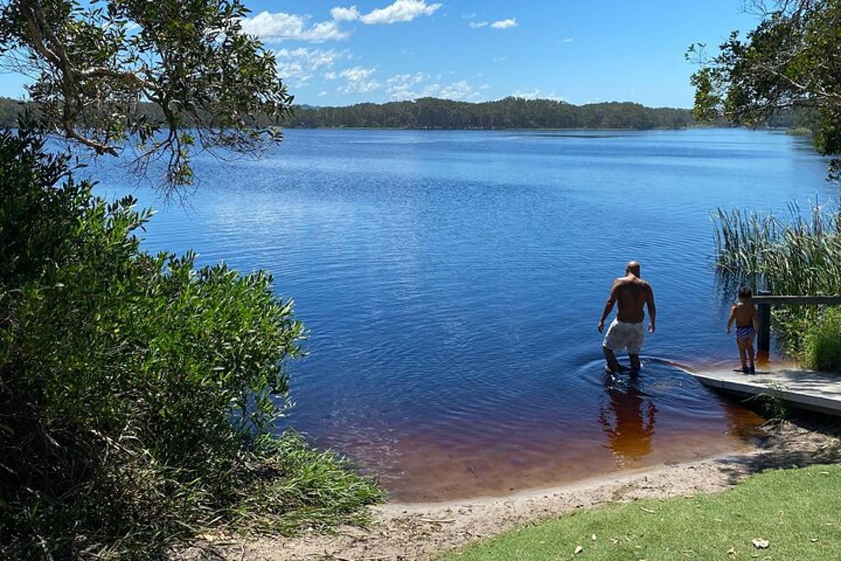 a man and a child walking into a lake