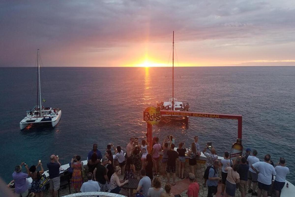 a group of people watching the sunset on a boat