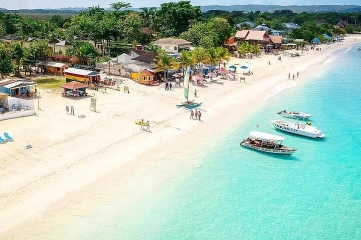 an aerial view of a beach with boats in the water