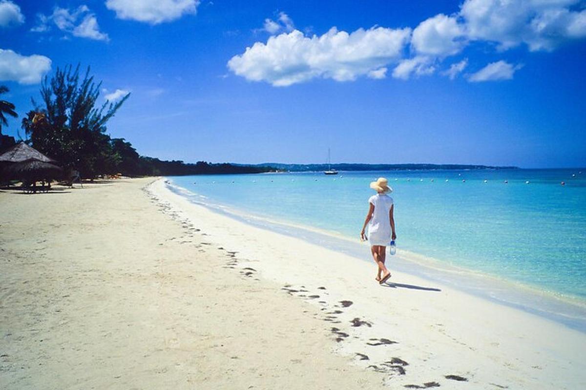 a woman walking on a beach with footprints in the sand