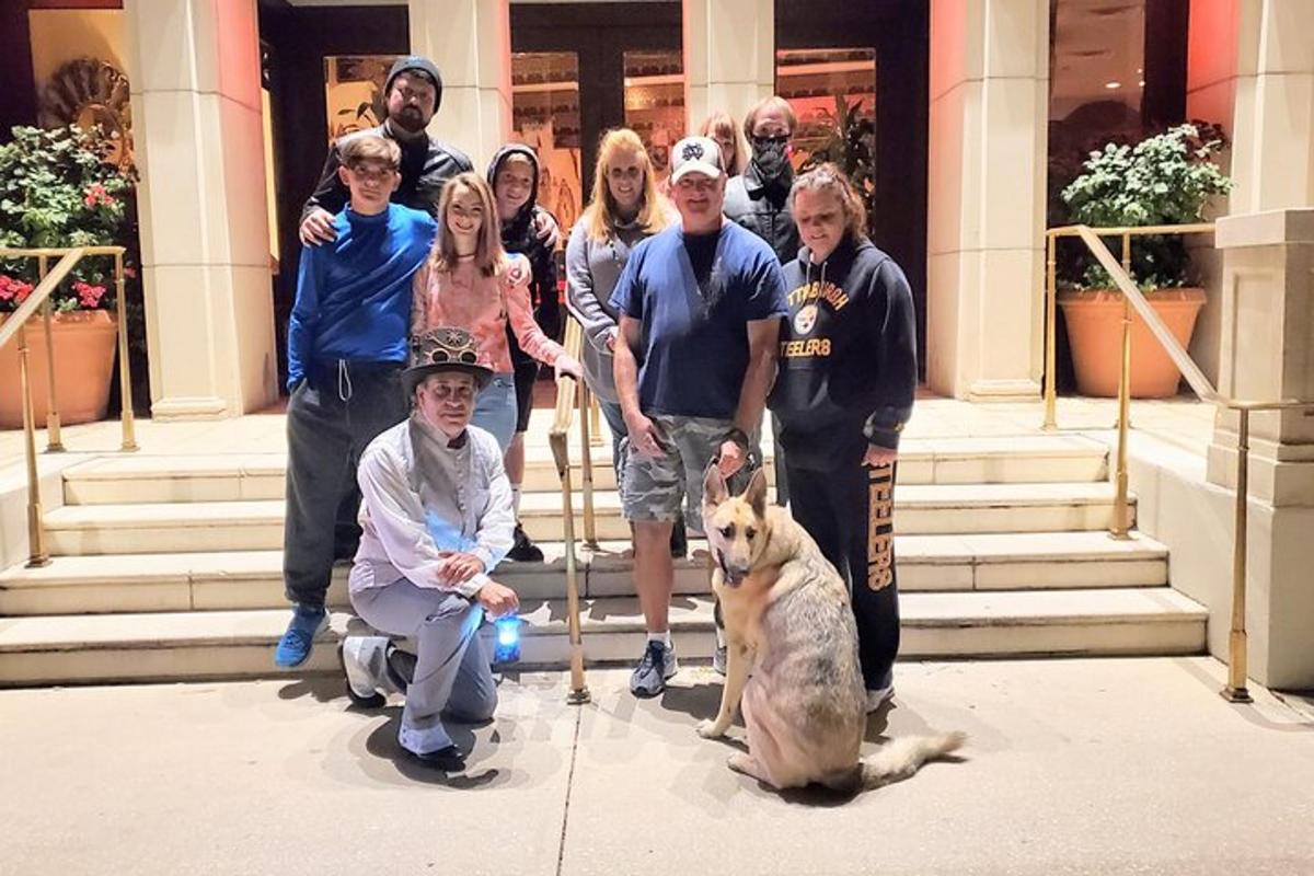 a group of people standing in front of a building with a dog