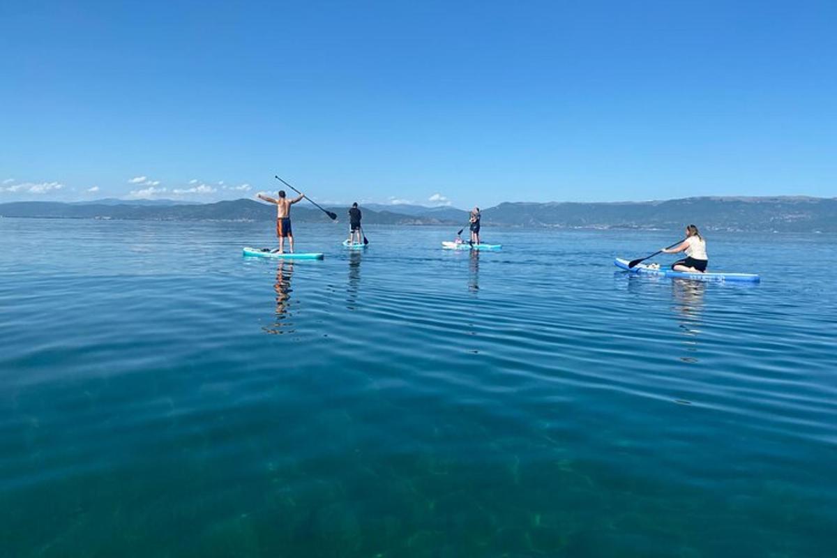 eine Gruppe von Menschen auf Surfbrettern im Wasser