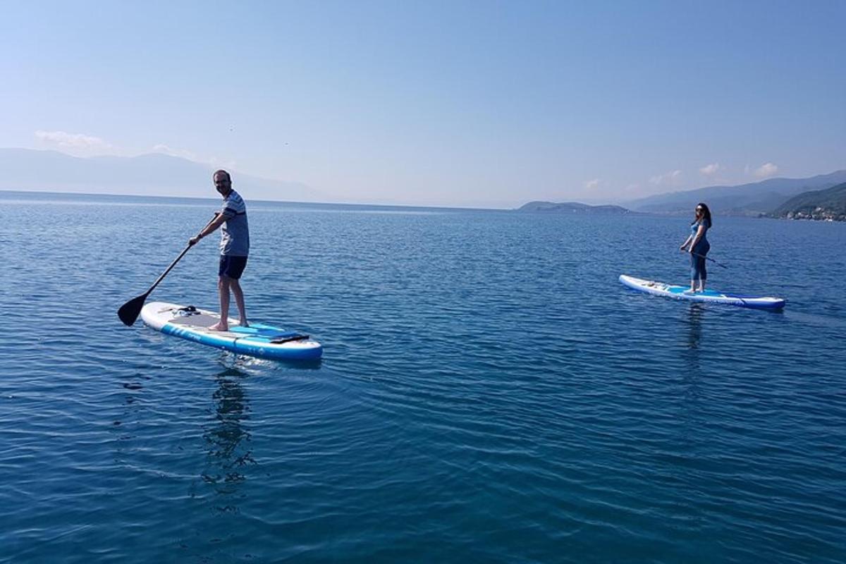 a man and a woman on paddle boards in the water