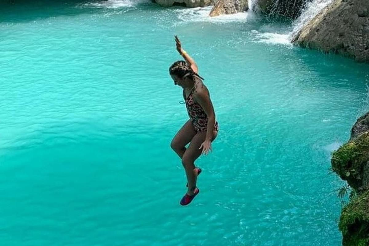una donna che salta in uno specchio d'acqua