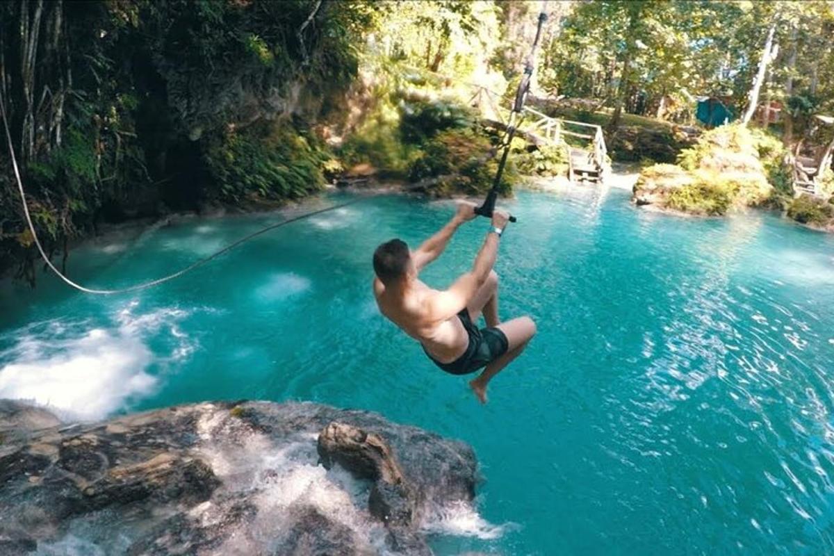 un uomo appeso a una corda in uno specchio d'acqua