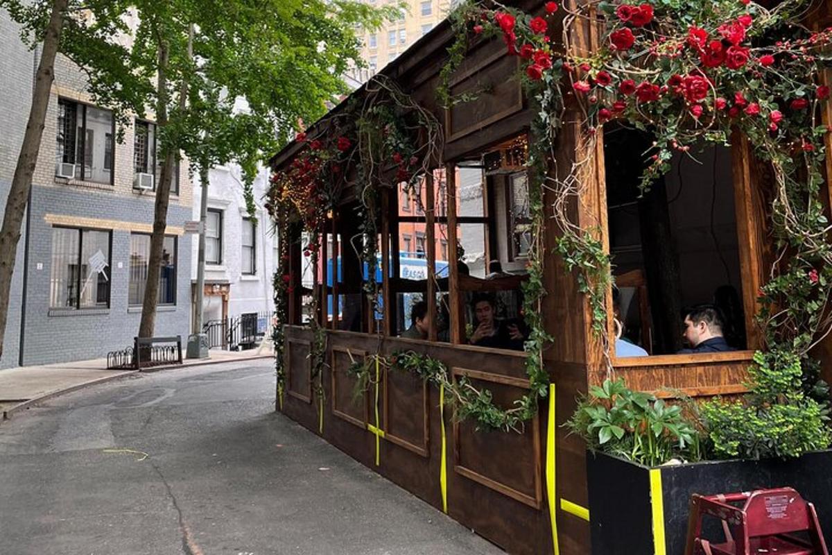 restaurace s lidmi sedícími uvnitř na ulici