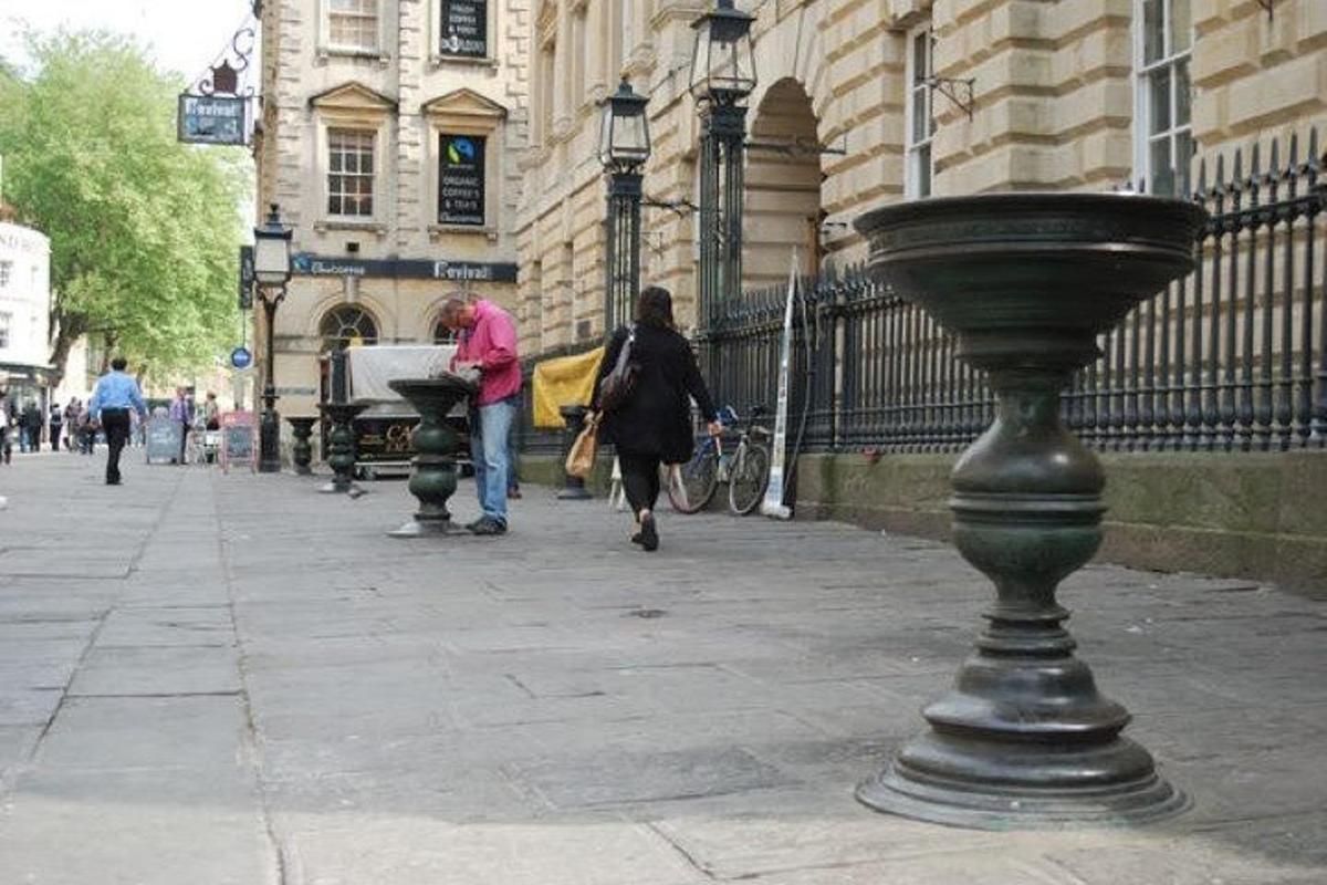 ženska, ki hodi po ulici s fontano