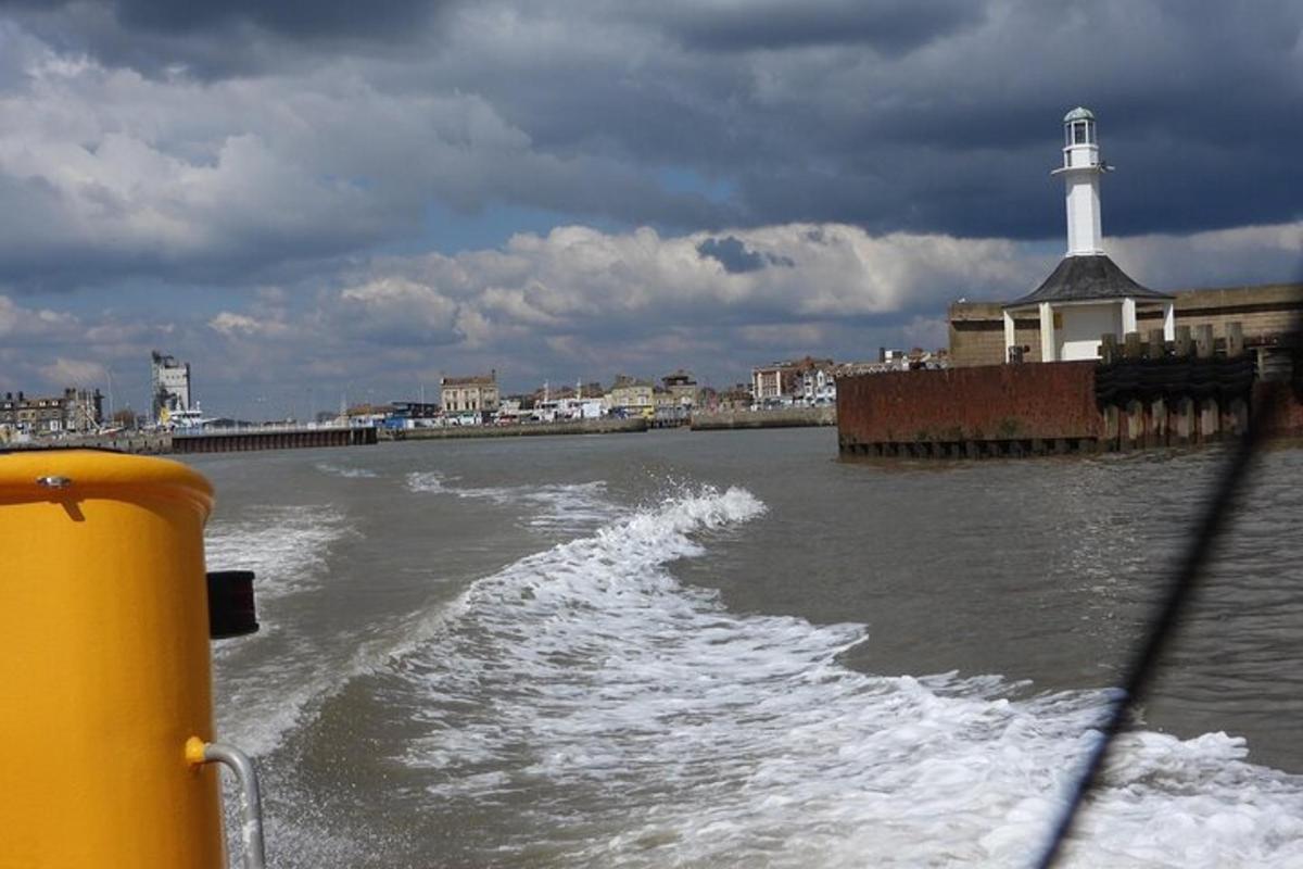 a boat in the water with a lighthouse in the background