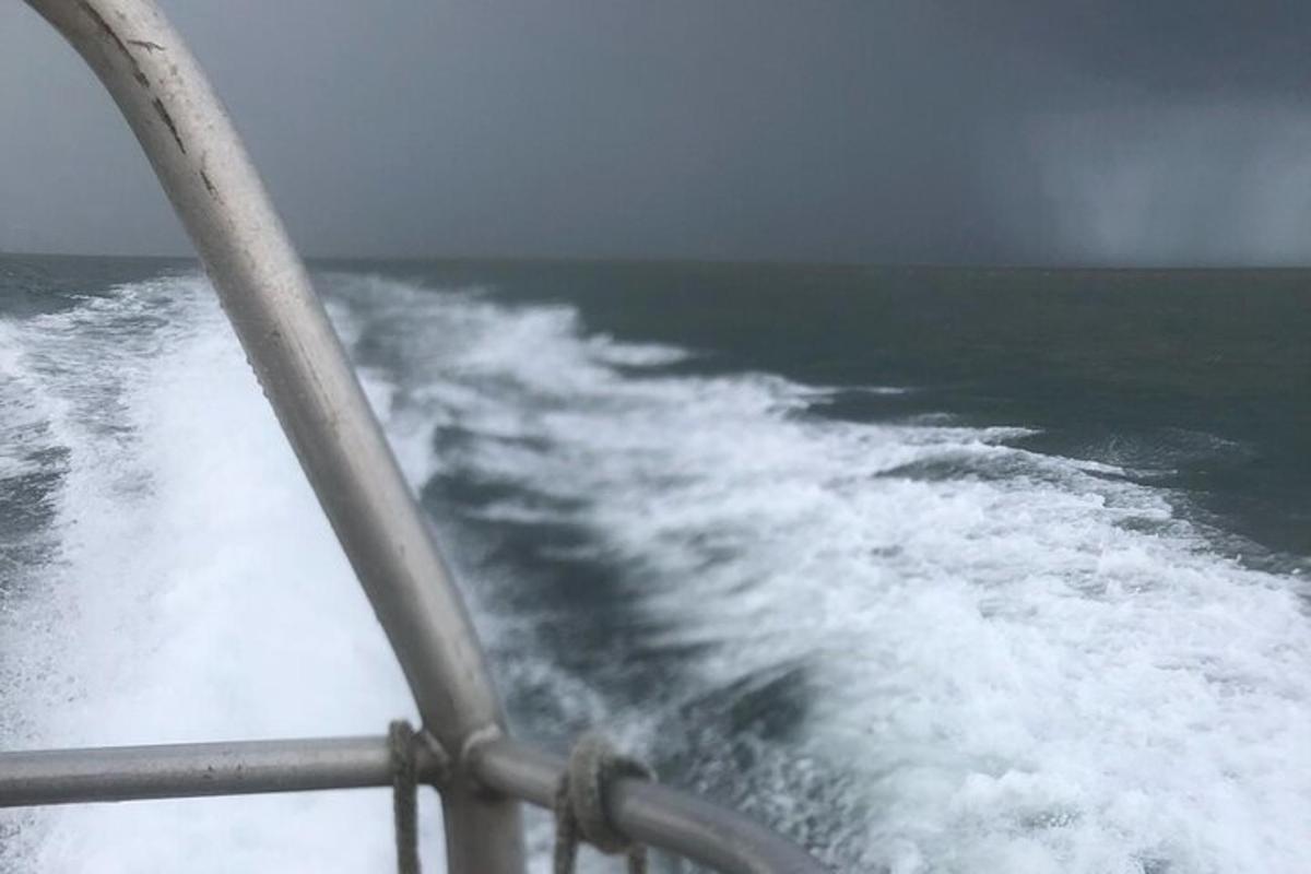 a boat in the ocean with a wave