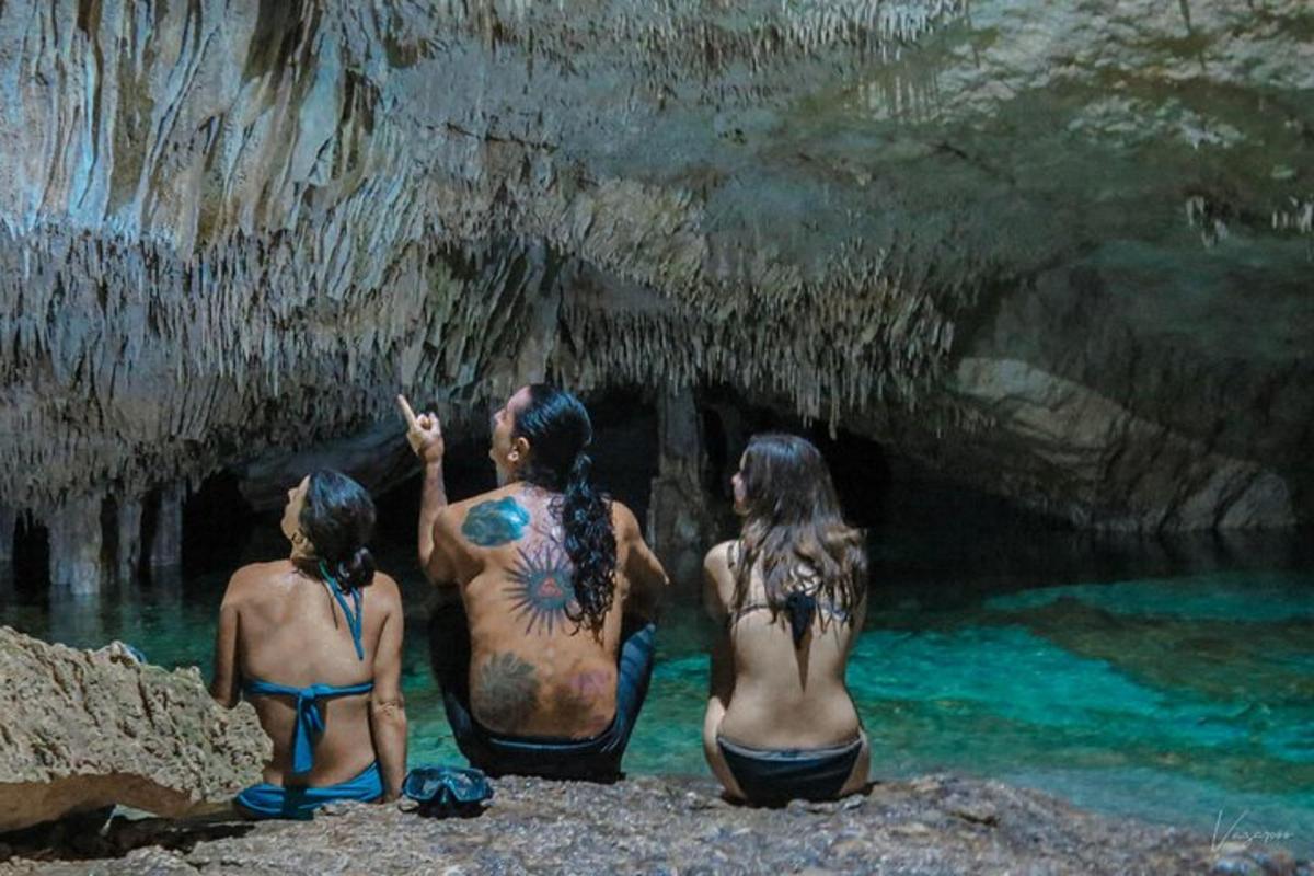 three women sitting in the water in a cave