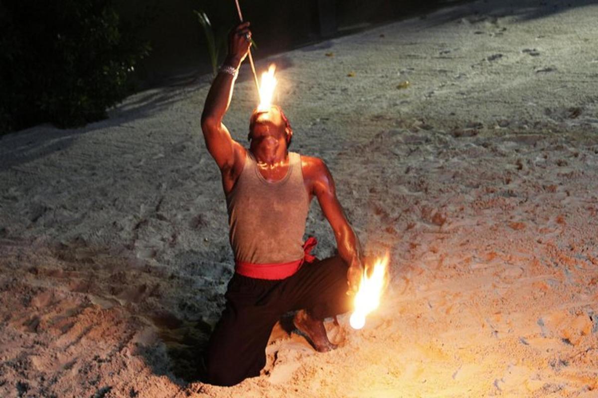 moški z baklami na glavi na plaži