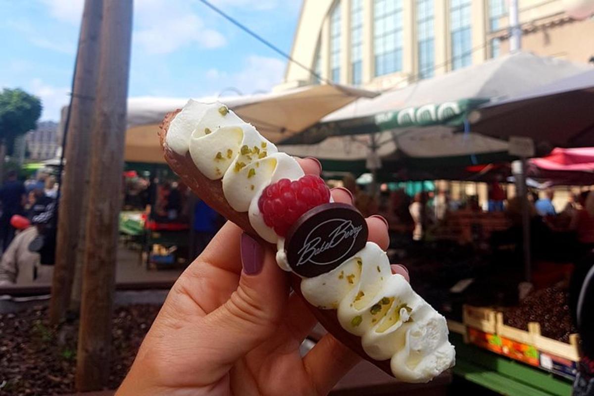 una persona che tiene in mano una banana split con della frutta sopra
