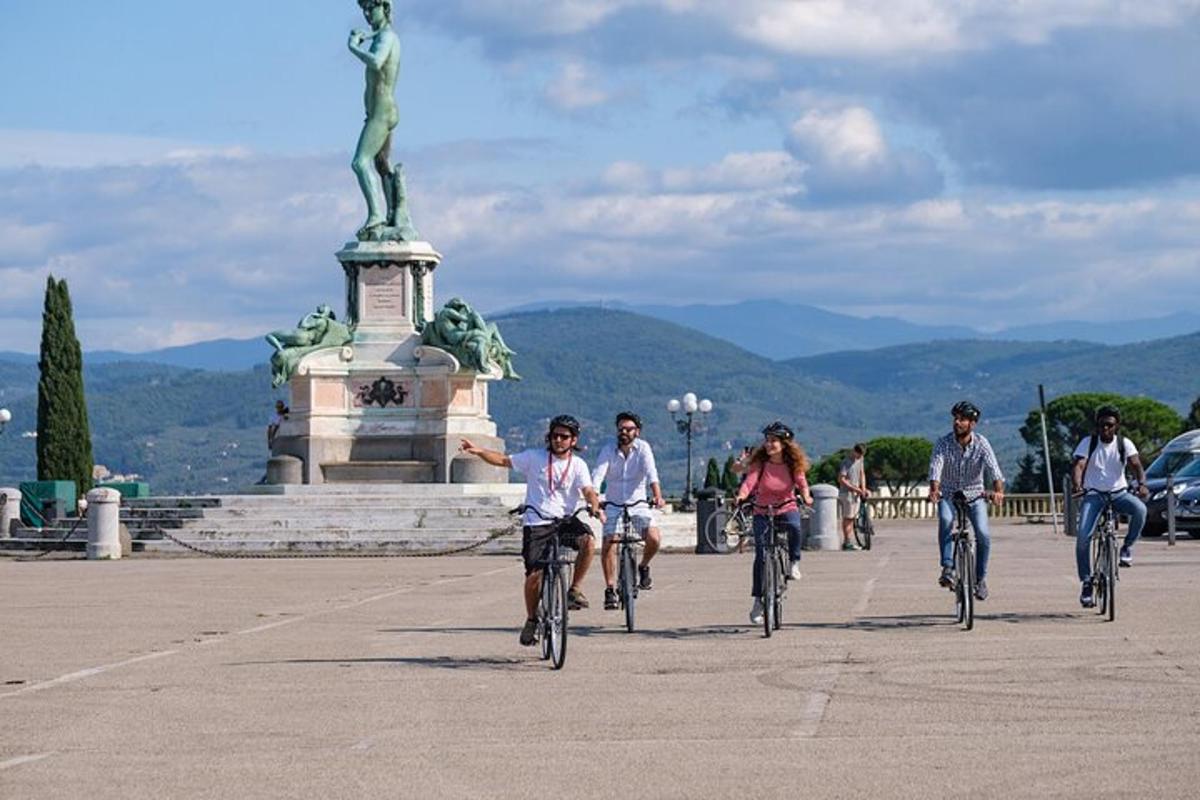 um grupo de pessoas andando de bicicleta em frente a uma estátua