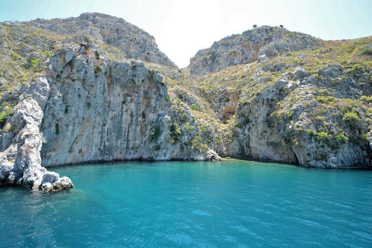a large pool of blue water next to a mountain