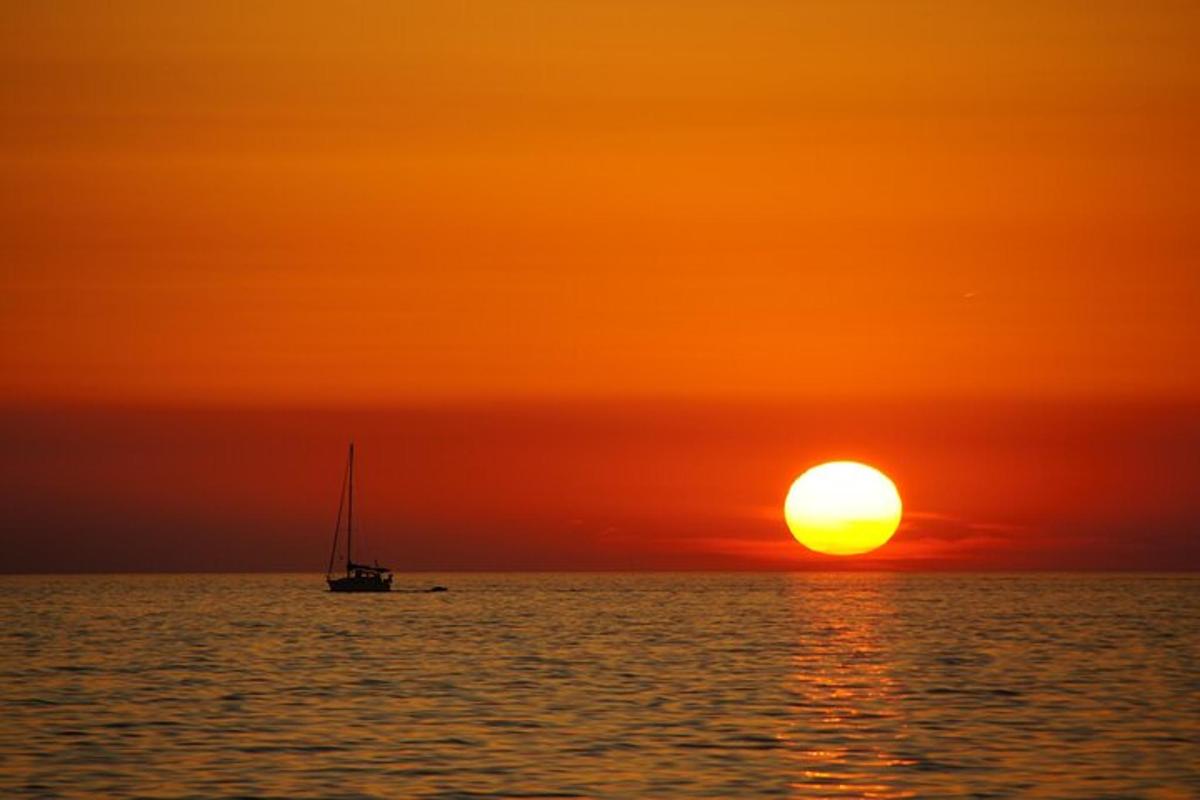 a boat in the ocean at sunset