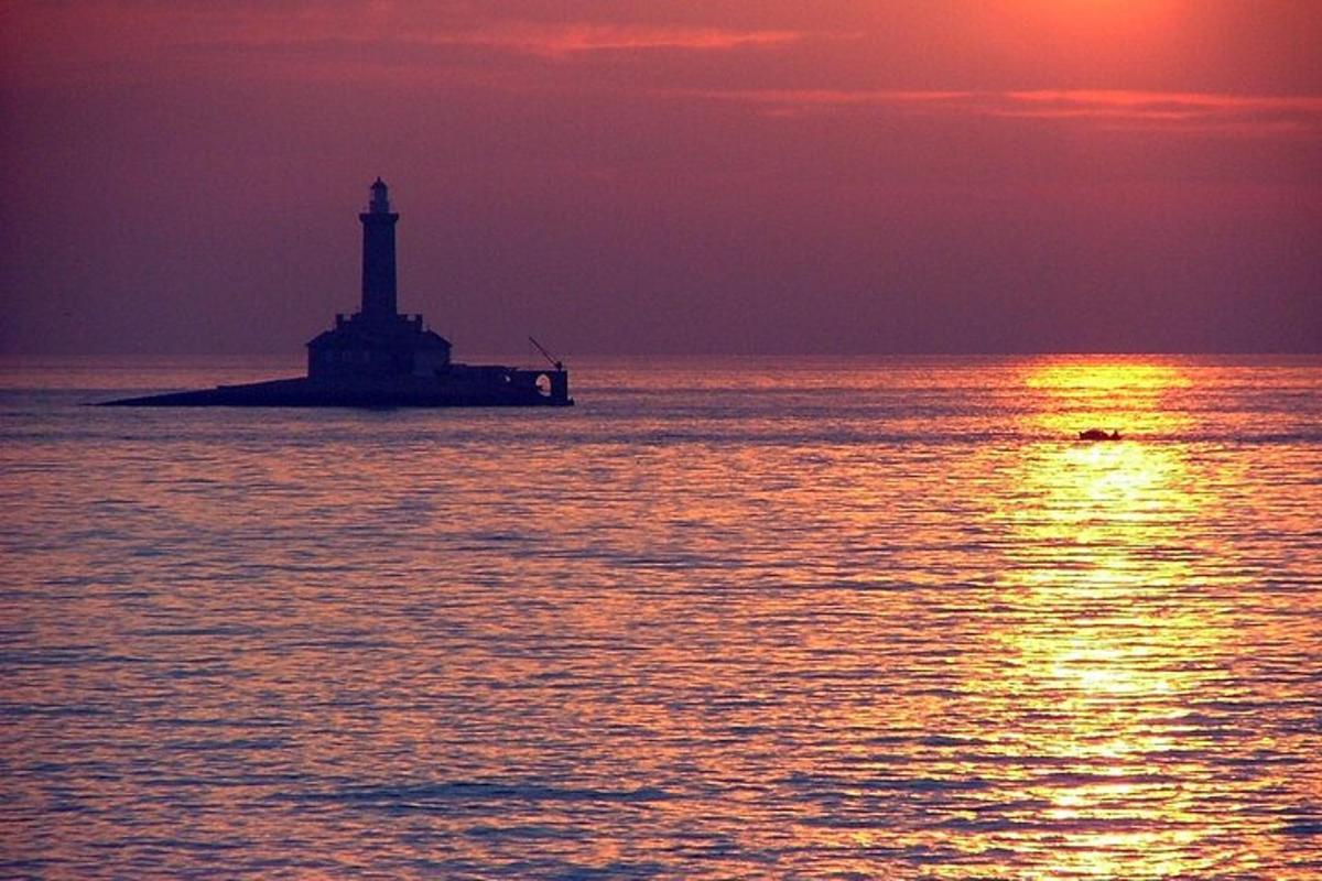 un faro su un'isola nell'oceano al tramonto