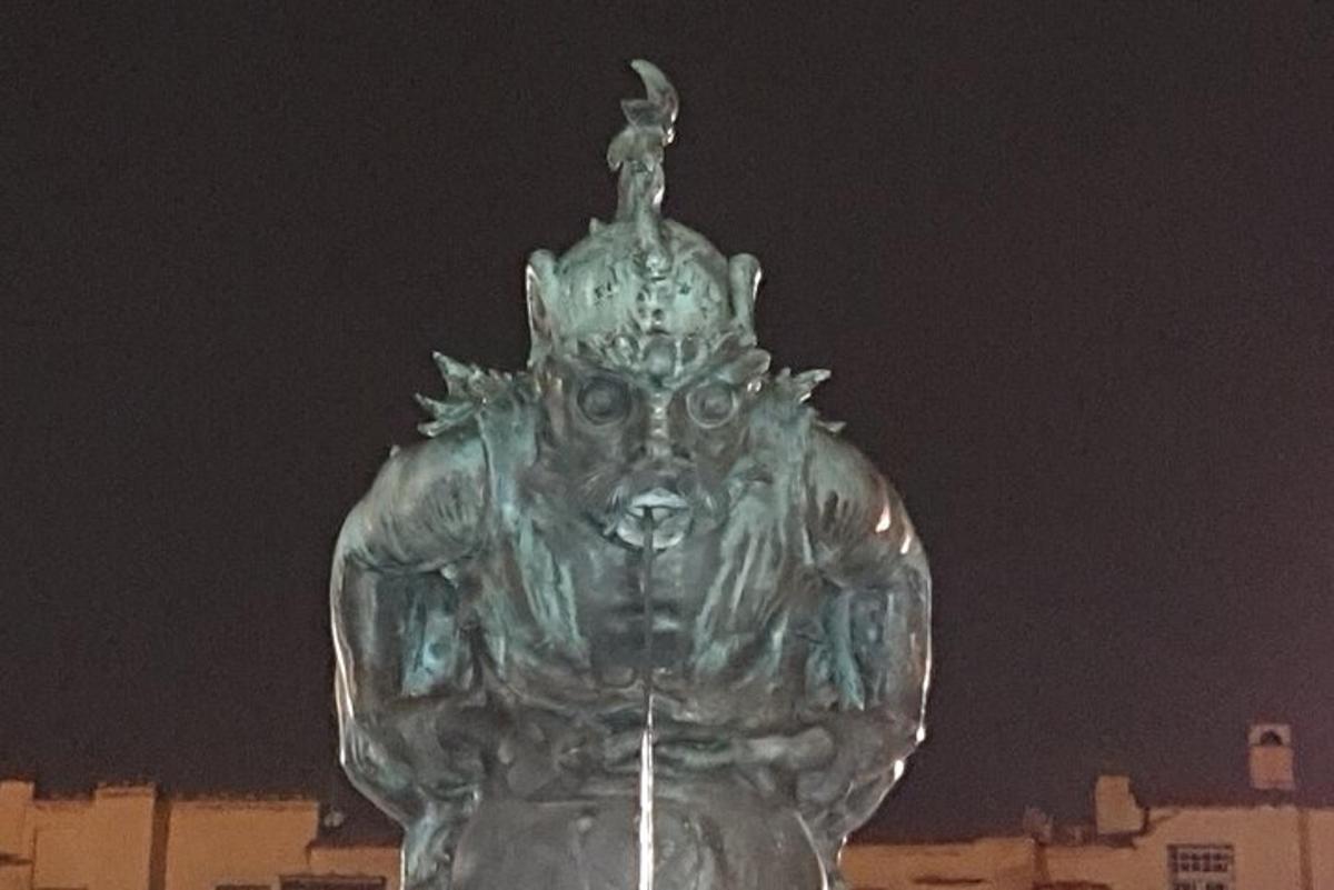 een groen standbeeld van een standbeeld voor een gebouw