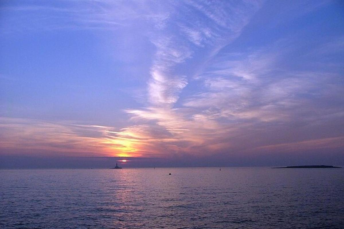 un tramonto sull'oceano con il sole che tramonta