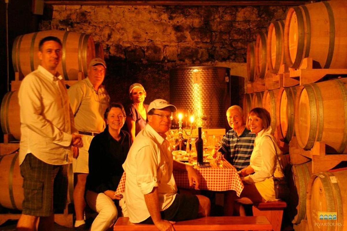a group of people posing in a wine cellar