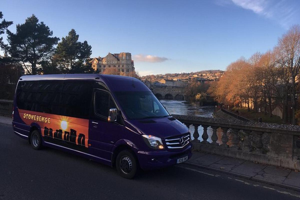 a purple van driving down a road next to a bridge