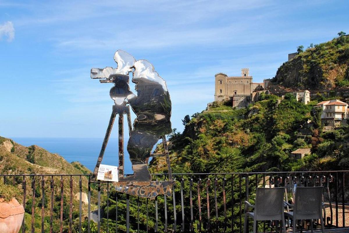 una statua di una macchina fotografica con un castello sullo sfondo